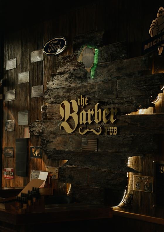 Parede de madeira com o logotipo The Barber Pub